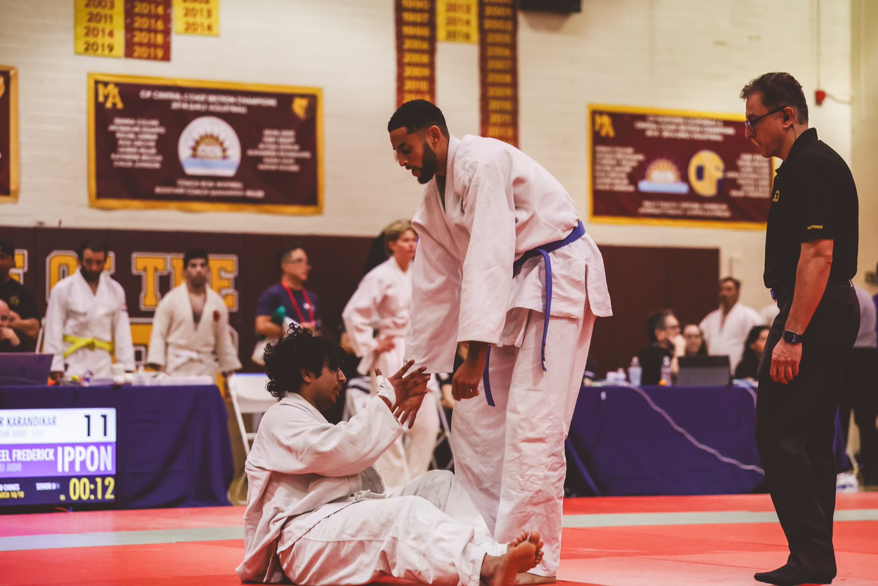 A Kensei coach spotting a young student through a throw